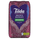 A 1kg bag of Tilda - Brown Basmati with a purple design, white patterned hands, and a gluten free label on the front.